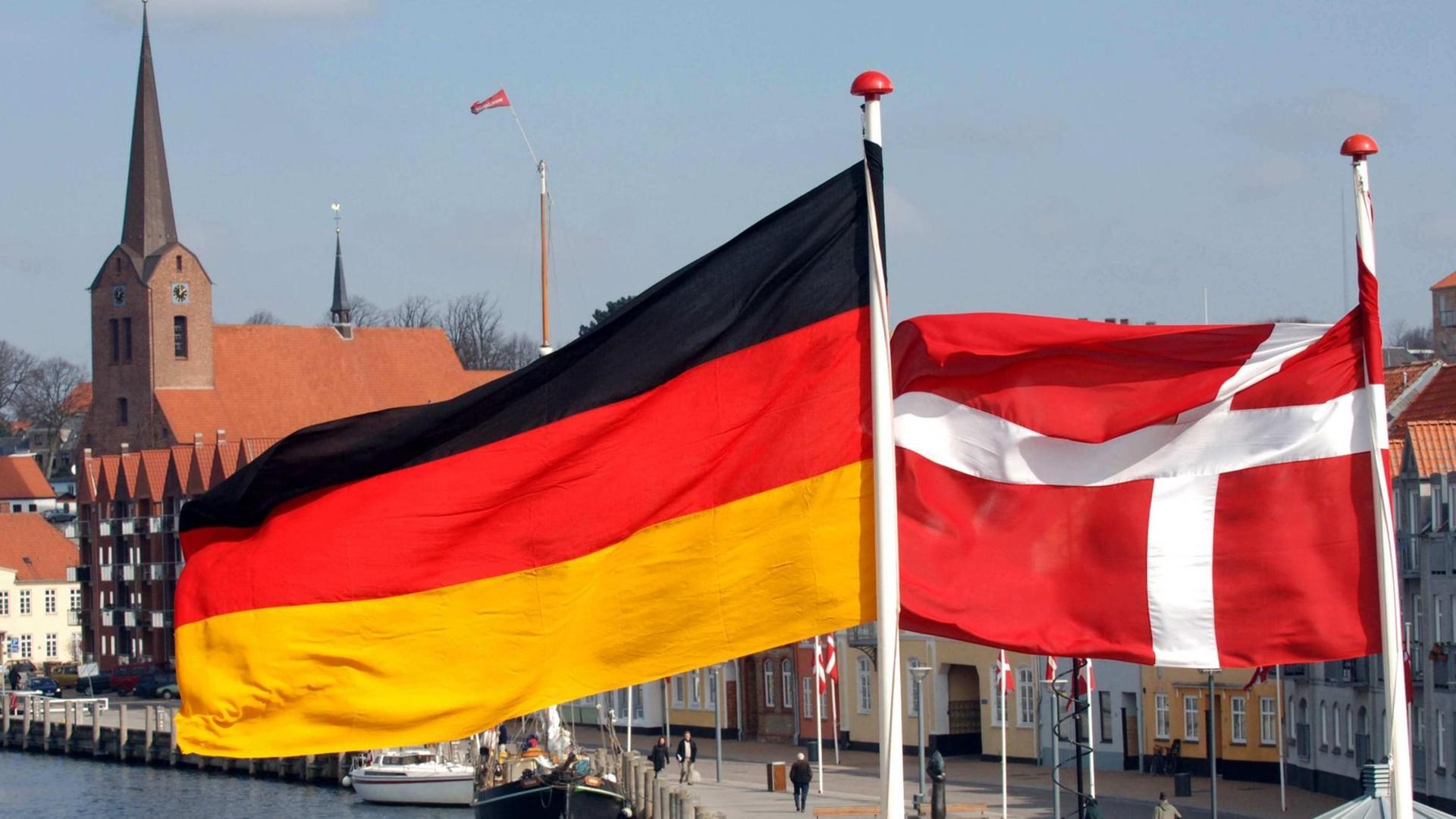 Die Flaggen von Dänemark und Deutschland wehen im dänischen Sonderburg über dem Hafen. Die Flaggen von Dänemark und Deutschland wehen im dänischen Sonderburg über dem Hafen.