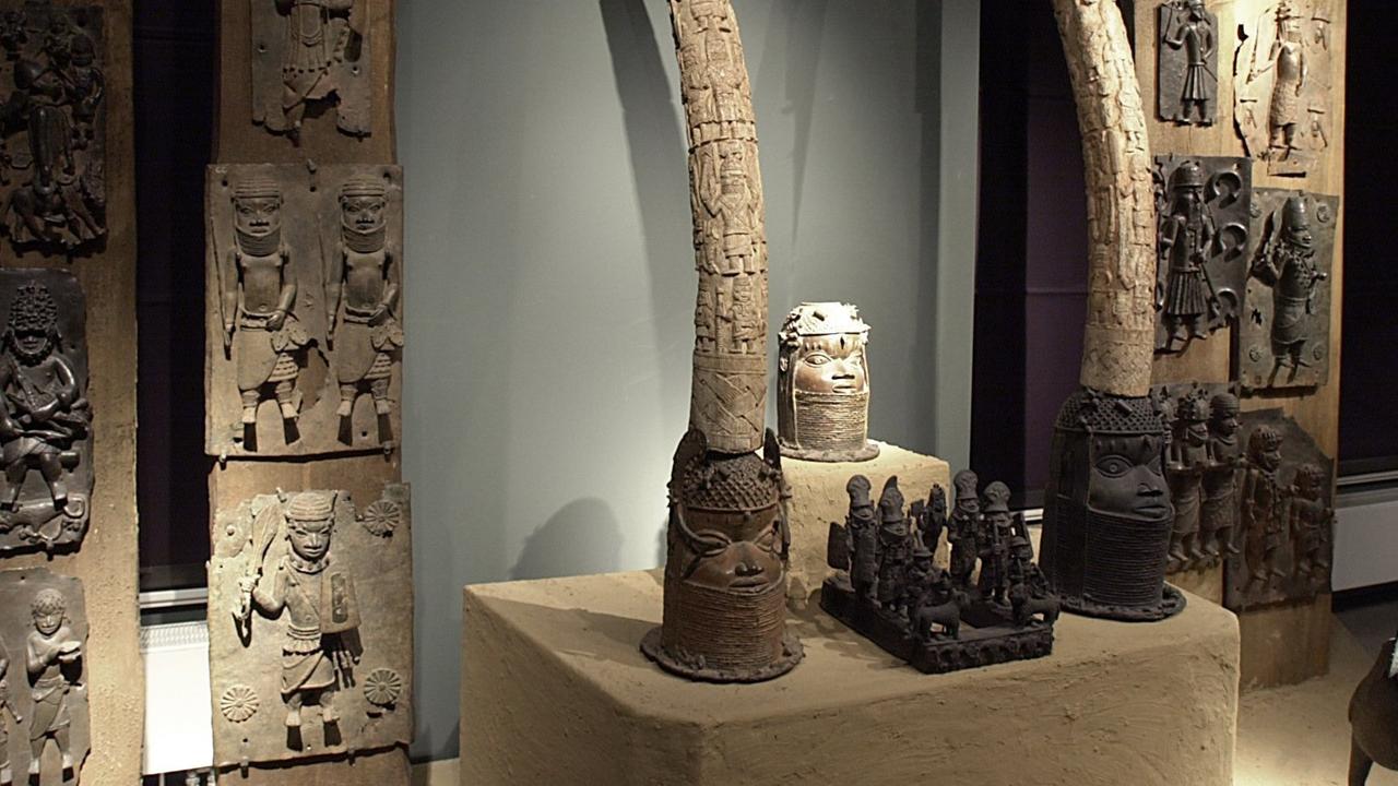 In einer Ausstellung von Kunstwerken aus dem früheren Königreich Benin sind Skulpturen, Elefantenstoßzähne und Wandplatten zu einem Altar auf einer Lehmplattform zusammengestellt. In einer Ausstellung von Kunstwerken aus dem früheren Königreich Benin sind Skulpturen, Elefantenstoßzähne und Wandplatten zu einem Altar auf einer Lehmplattform zusammengestellt.