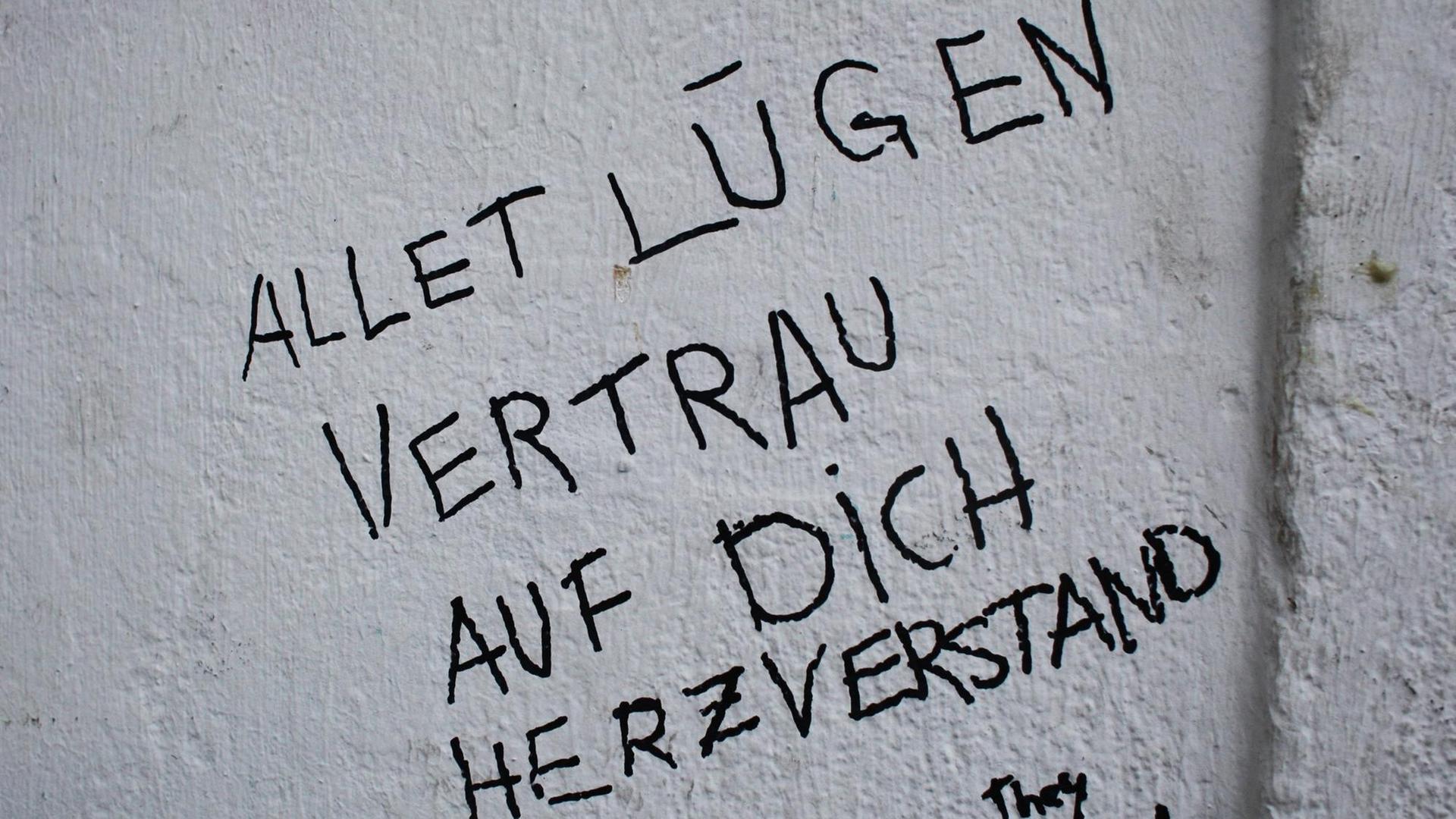 Auf einer Wand steht mit Filzschrift geschrieben: "Allet Lügen. Vertrau auf dich, Herzverstand" Auf einer Wand steht mit Filzschrift geschrieben: "Allet Lügen. Vertrau auf dich, Herzverstand"