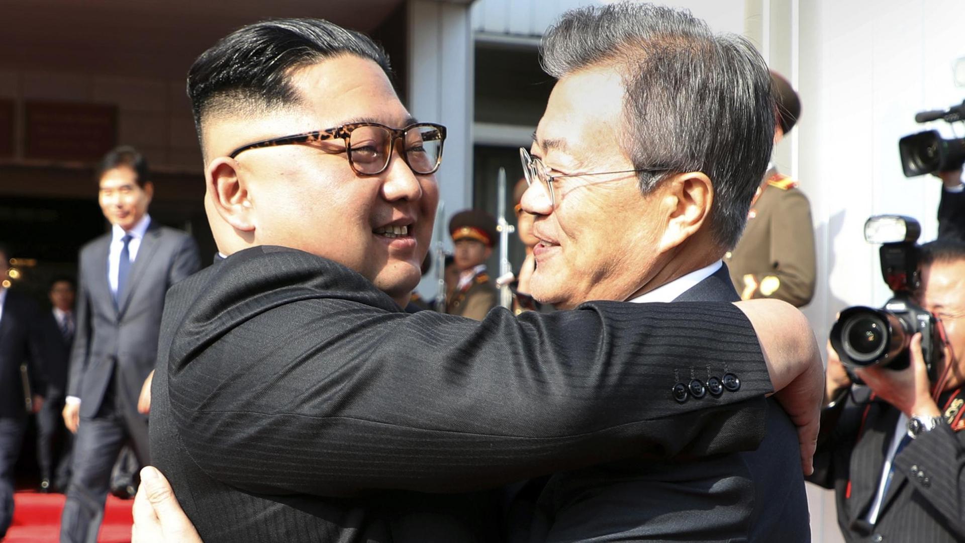 Dieses vom Blauen Haus, dem südkoreanischen Präsidialamt zur Verfügung gestellte Foto zeigt Kim Jong Un (l), Machthaber in Nordkorea, und Moon Jae In, Präsident von Südkorea, die sich vor einem zweiten Treffen auf der nördlichen Seite der Grenze in der demilitarisierten Grenzstadt Panmunjom umarmen. Dieses vom Blauen Haus, dem südkoreanischen Präsidialamt zur Verfügung gestellte Foto zeigt Kim Jong Un (l), Machthaber in Nordkorea, und Moon Jae In, Präsident von Südkorea, die sich vor einem zweiten Treffen auf der nördlichen Seite der Grenze in der demilitarisierten Grenzstadt Panmunjom umarmen.