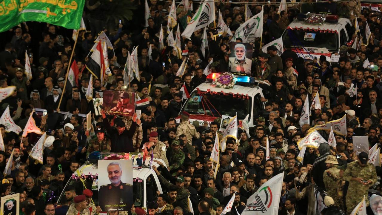 Trauernde umgeben Autos, die die Särge des erschlagenen irakischen Paramilitärchefs Abu Mahdi al-Muhandis, des iranischen Militärkommandanten Qasem Soleimani und acht Anderer. Trauernde umgeben Autos, die die Särge des erschlagenen irakischen Paramilitärchefs Abu Mahdi al-Muhandis, des iranischen Militärkommandanten Qasem Soleimani und acht Anderer.