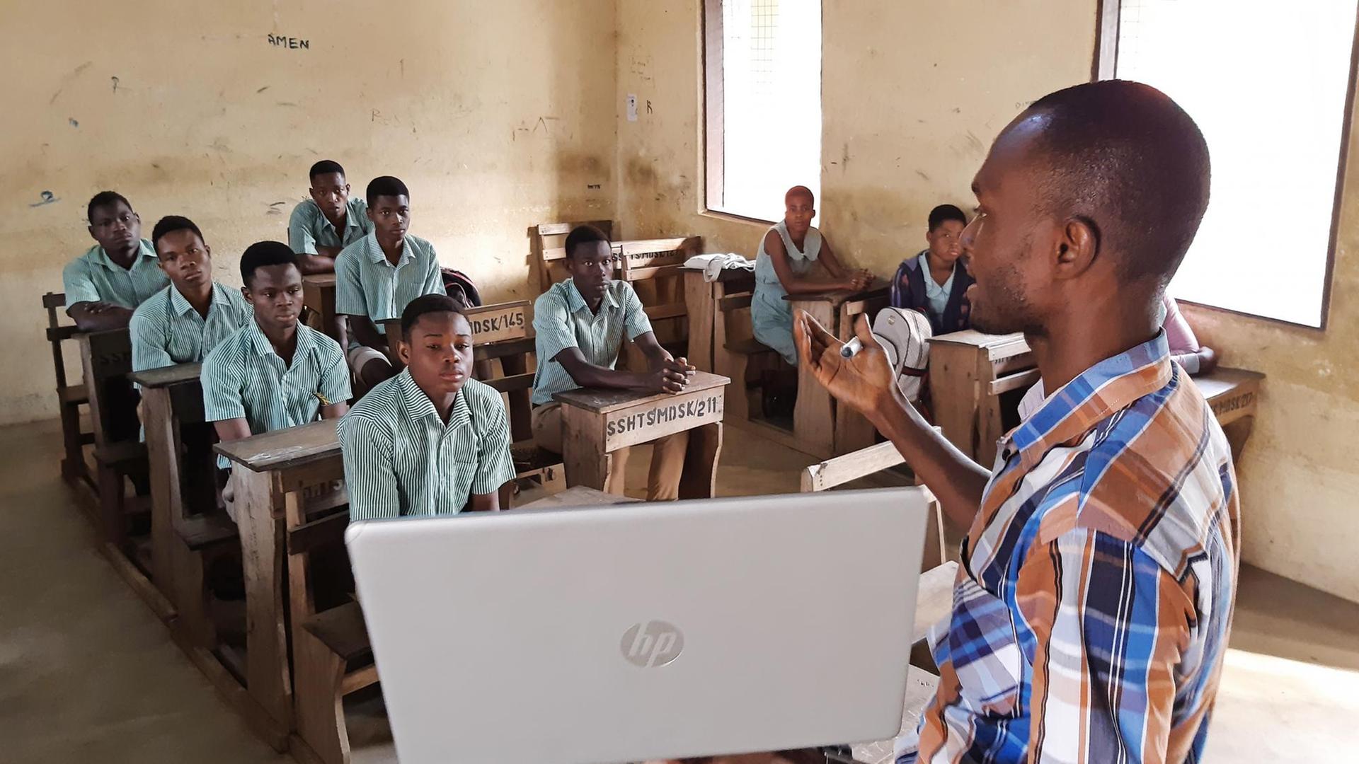 Der Lehrer Earnest Adomensa zeigt den Schülerinnen und Schülern das Microsoft Startmenü auf seidem privaten Laptop. Der Lehrer Earnest Adomensa zeigt den Schülerinnen und Schülern das Microsoft Startmenü auf seidem privaten Laptop.