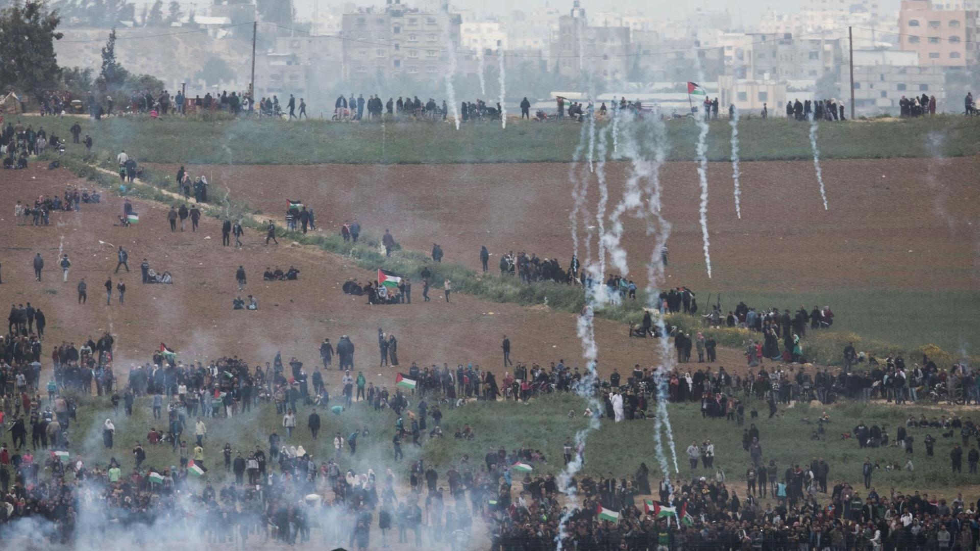 Palästinenser versammeln sich für den "Marsch der Rückkehr" an der Grenze zu Israel, während die israelische Armee Tränengas einsetzt. Palästinenser versammeln sich für den "Marsch der Rückkehr" an der Grenze zu Israel, während die israelische Armee Tränengas einsetzt.