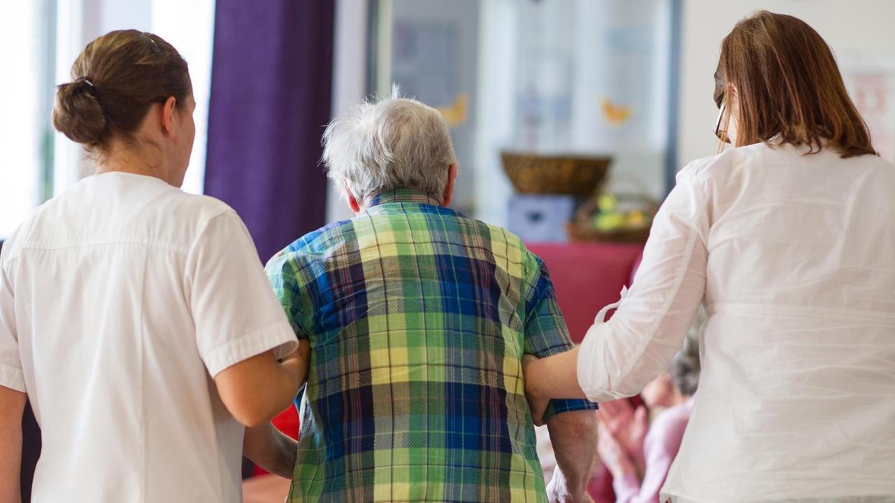 Zwei Pflegerinnen stützen in Heilbronn in einem Pflegeheim einen Bewohner. Zwei Pflegerinnen stützen in Heilbronn in einem Pflegeheim einen Bewohner.