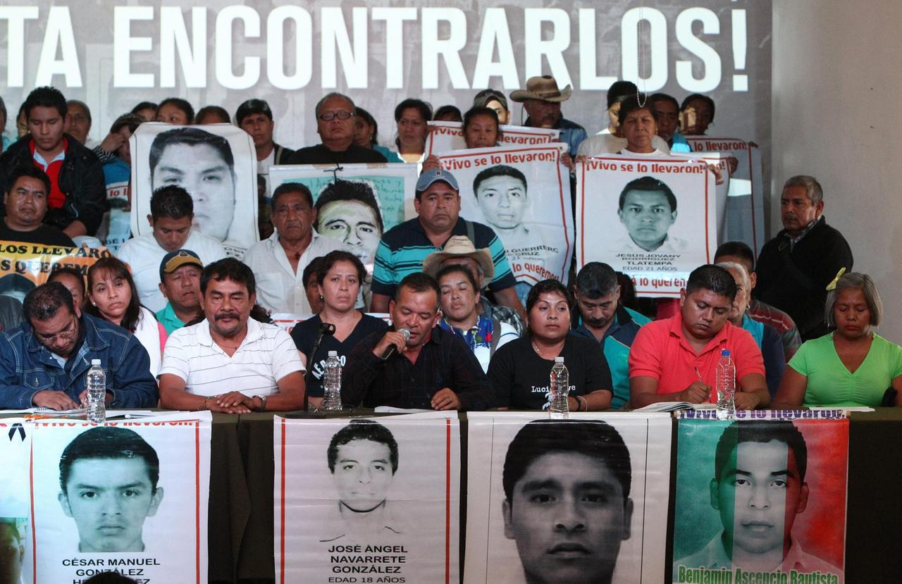 Die Eltern und Studienkollegen der 43 vermissten Studenten aus Mexiko halten Fotos von ihnen hoch.