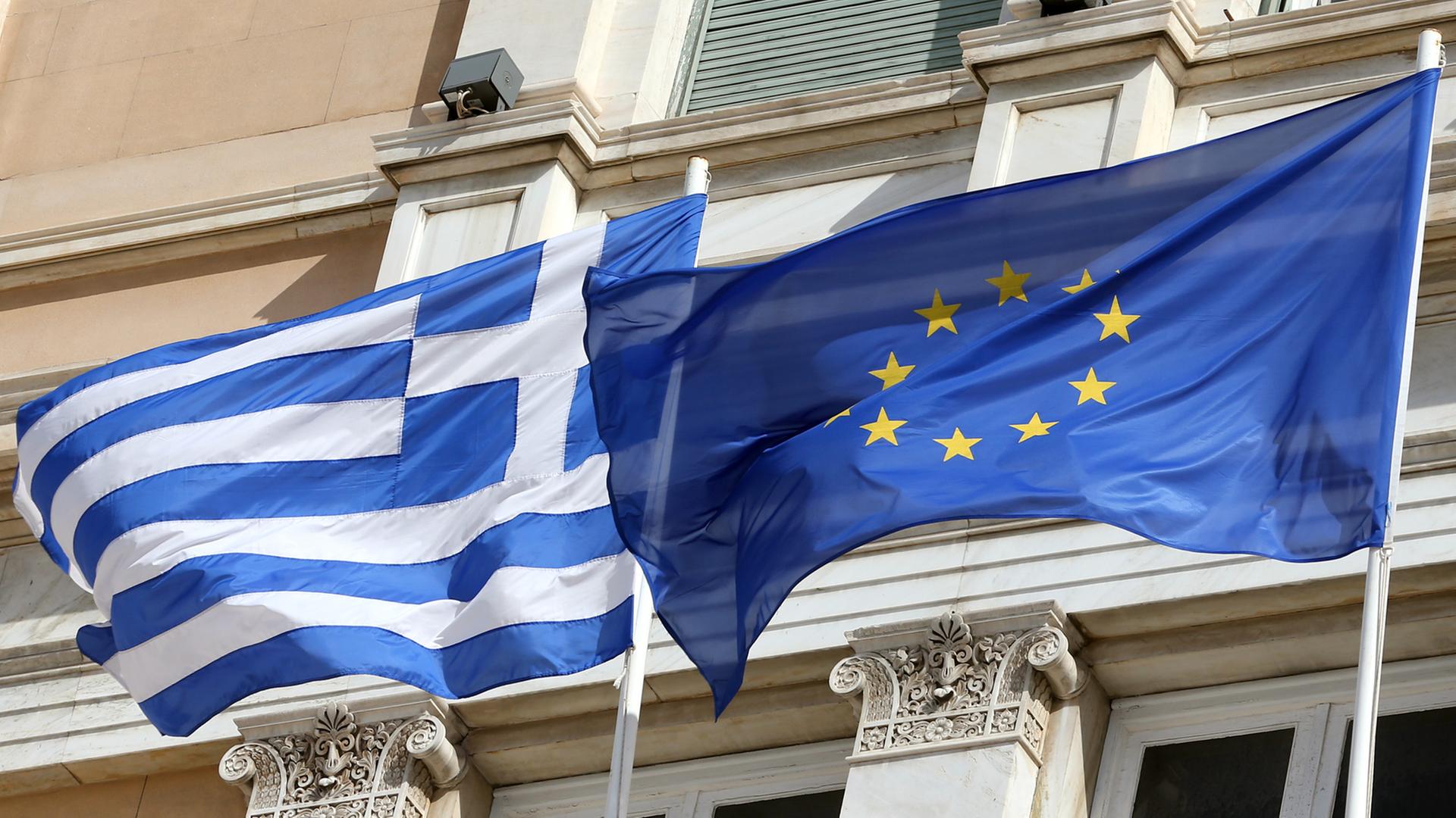 Die griechische und die europäische Flagge wehen vor dem Parlamentsgebäude in Athen. Die griechische und die europäische Flagge wehen vor dem Parlamentsgebäude in Athen.