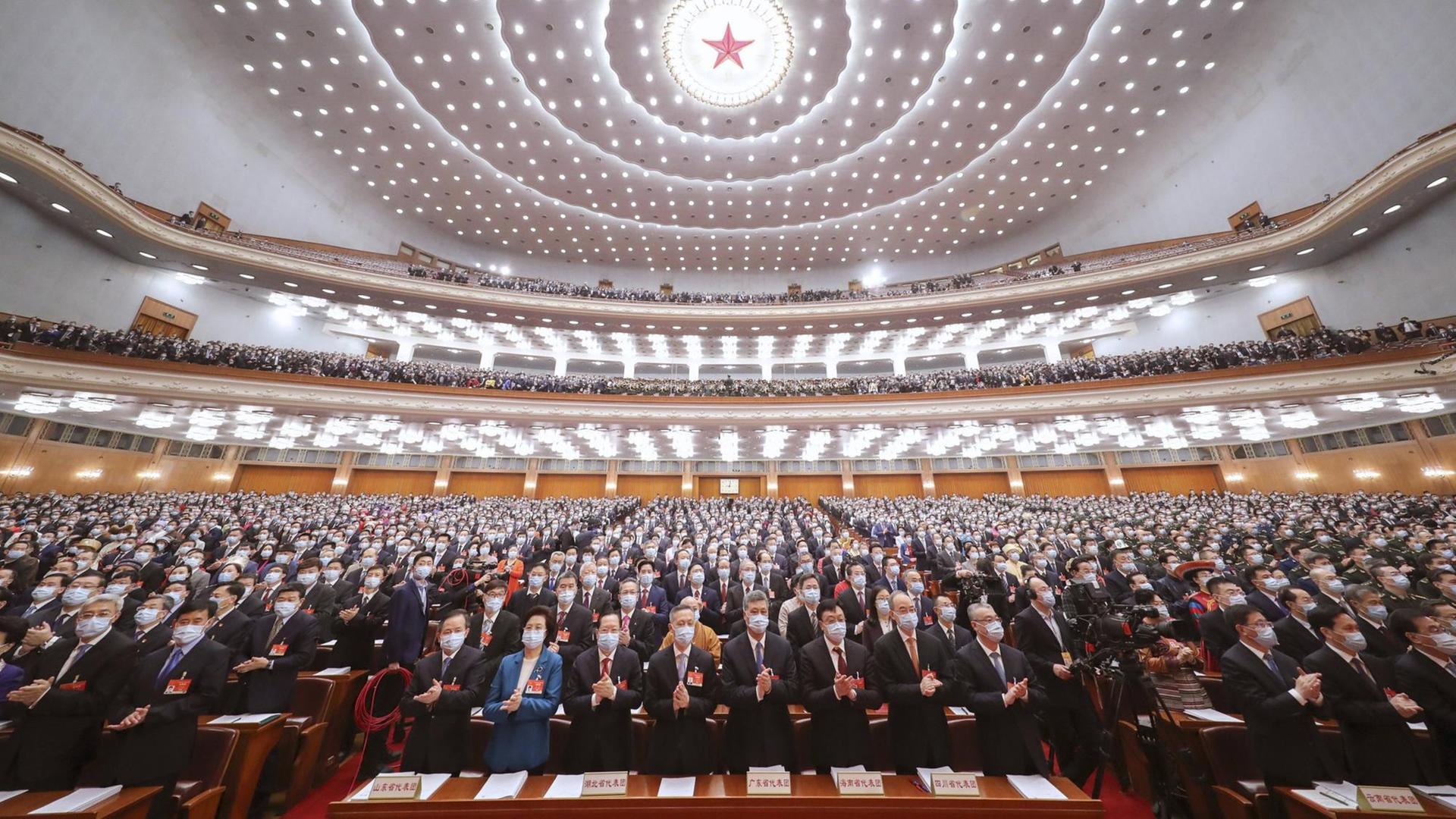 Beim 13. Nationale Volkskongress in China in Peking stehen die Teilnehmer auf und klatschen. Beim 13. Nationale Volkskongress in China in Peking stehen die Teilnehmer auf und klatschen.