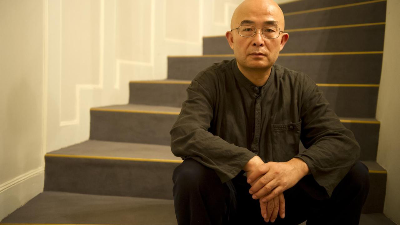 Der chinesische Schriftsteller Liao Yiwu, Träger des Friedenspreises des Deutschen Buchhandels 2012, sitzt im Deutschen Theater in Berlin nach einer Lesung auf einer Treppe. 