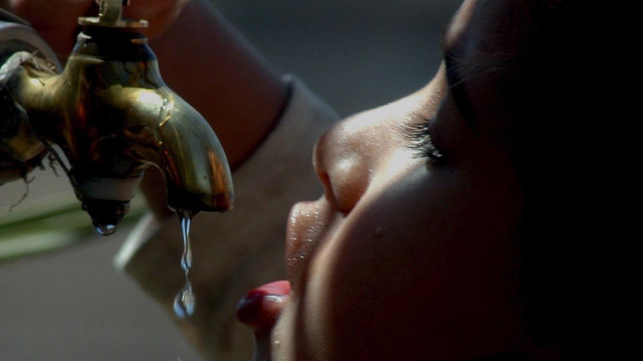 Ein jemenitisches Kind trinkt an einem Wasserhahn. Ein jemenitisches Kind trinkt an einem Wasserhahn.