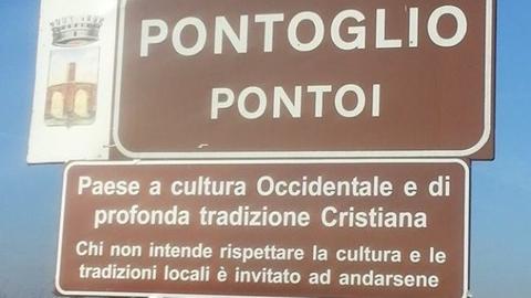 Schild am Ortseingang von Pontoglio, Norditalien, mit der Aufschrift: "Dies ist ein Ort westlicher Kultur und tief empfundener christlicher Tradition – Wer nicht bereit ist diese Kultur und die lokalen Traditionen zu respektieren, wird dazu aufgefordert, unsere Stadt zu verlassen".