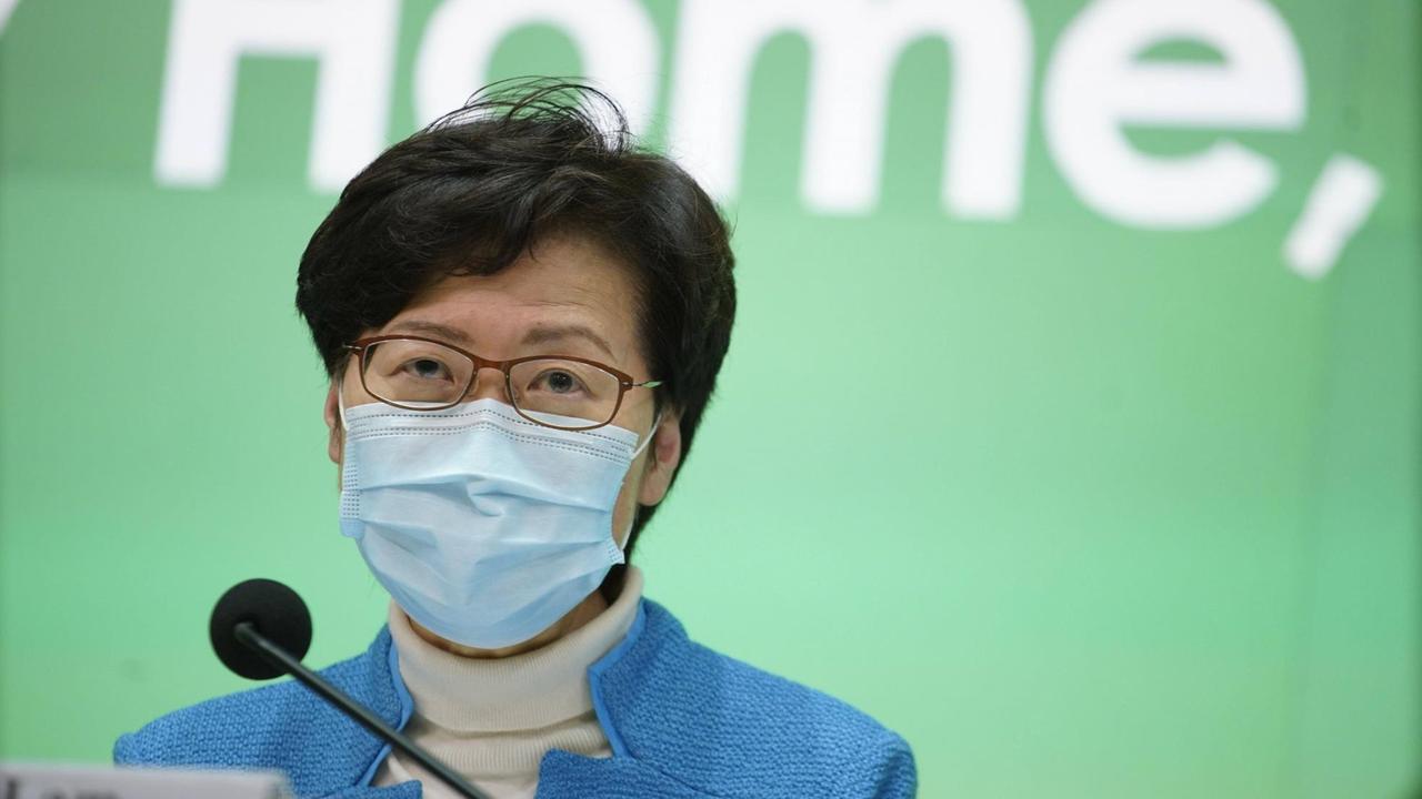 Die Regierungschefin von Hong Kong Carrie Lam mit einer Mundschutzmaske vor grünem Hintergrund.