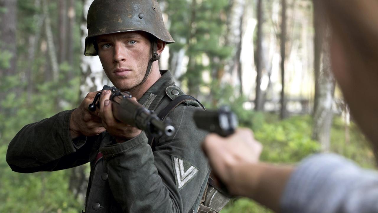 Ein Wehrmachtssoldat richtet das Gewehr auf eine Person, die ihn mit einer Pistole bedroht. Ein Wehrmachtssoldat richtet das Gewehr auf eine Person, die ihn mit einer Pistole bedroht.
