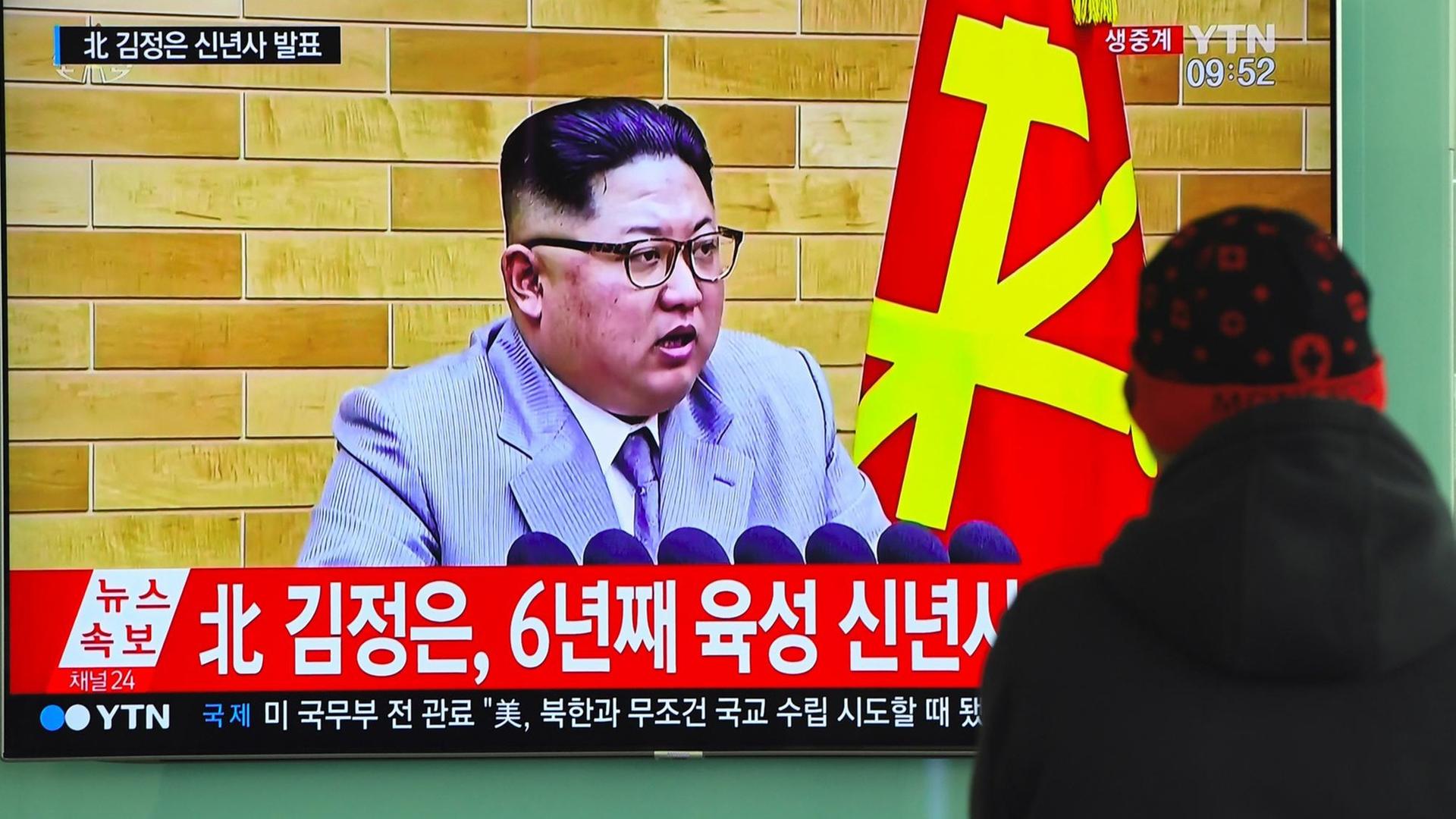 Ein Mann in Nordkorea schaut auf einen Fernsehbildschirm, auf dem Staatschef Kim Jong Un bei seiner Neujahrsansprache zu sehen ist