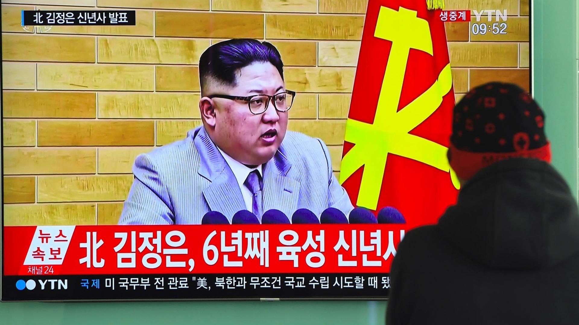 Ein Mann in Nordkorea schaut auf einen Fernsehbildschirm, auf dem Staatschef Kim Jong Un bei seiner Neujahrsansprache zu sehen ist Ein Mann in Nordkorea schaut auf einen Fernsehbildschirm, auf dem Staatschef Kim Jong Un bei seiner Neujahrsansprache zu sehen ist