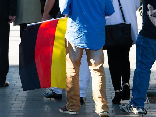 06.07.2019, Thüringen, Leinefelde: Ein Teilnehmer mit einer Deutschland-Flagge kommt zum Kyffhäusertreffen der AfD-Gruppierung "Der Flügel".