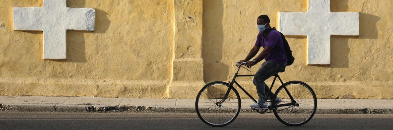 Ein Mann fährt mit dem Fahrrad an der Mauer des Colon-Friedhofes von Havanna entlang. Ein Mann fährt mit dem Fahrrad an der Mauer des Colon-Friedhofes von Havanna entlang.