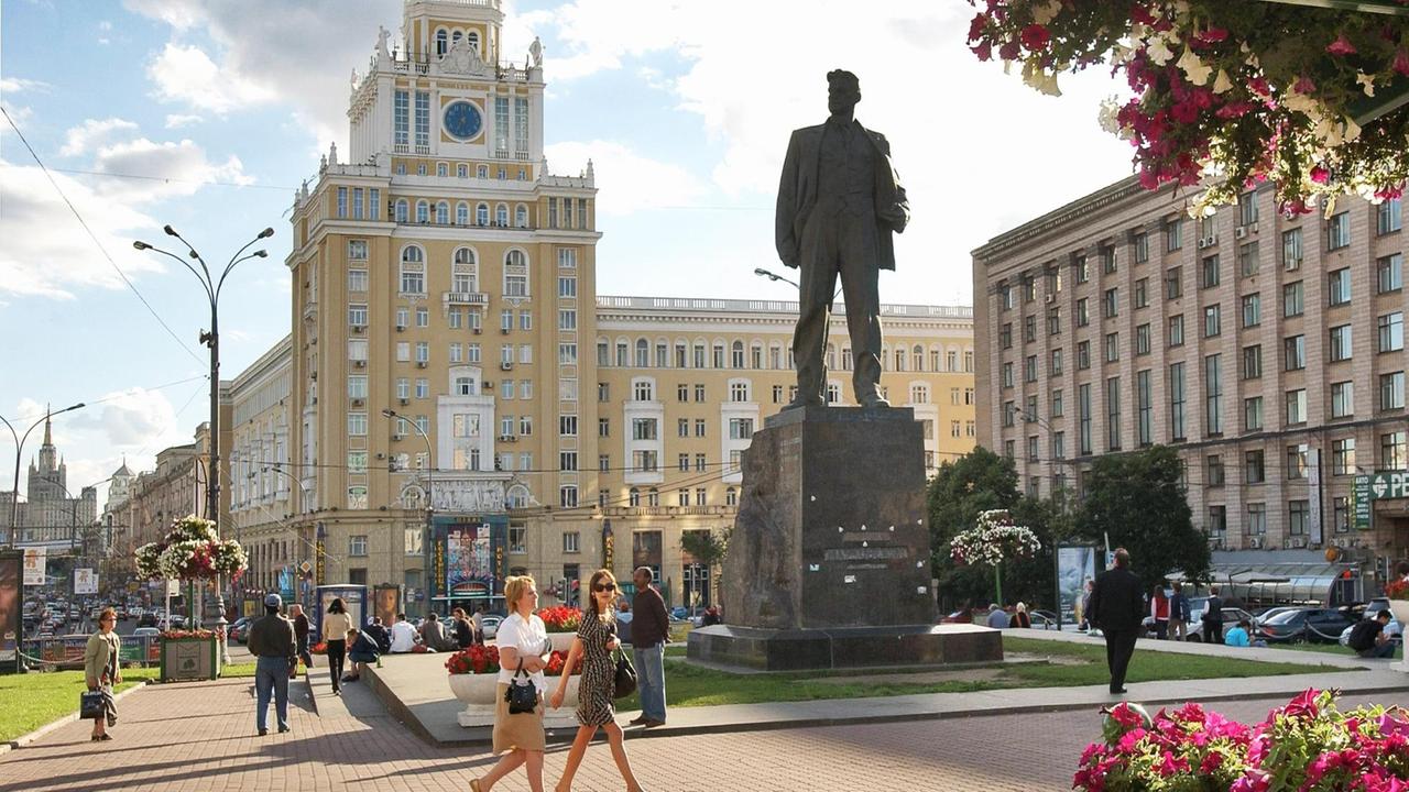 Ein belebter Platz rund um die Statue des Dichters Majakowski. Die Gebäude im Hintergrund sind im typisch prunkvollen Zuckerbäcker-Stil gehalten.