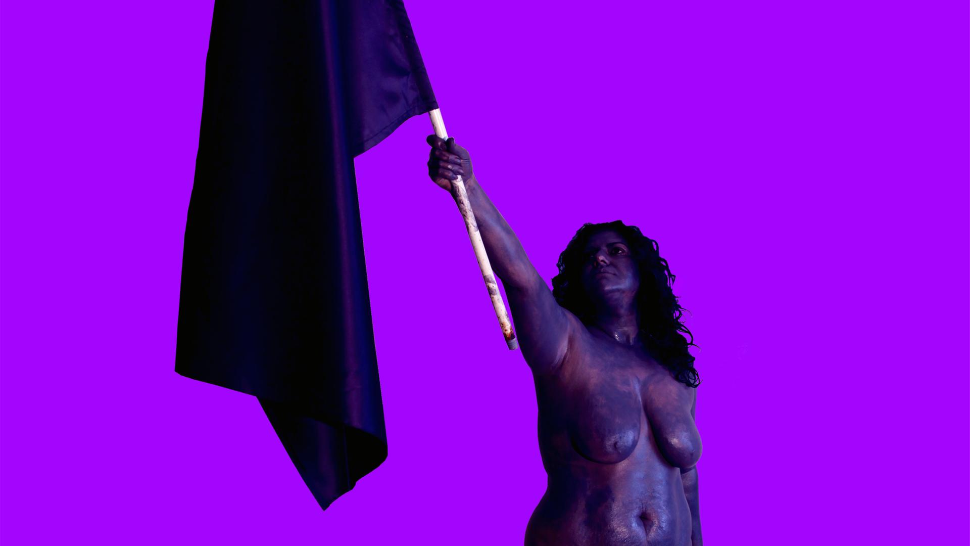 Die Künstlerin CANAN hält - nackt - eine Flagge in die Luft