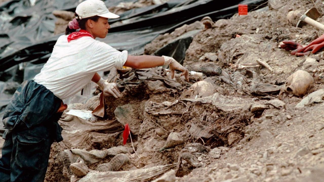 Juli 1996: Eine Mitarbeiterin des UN-Tribunals für Kriegsverbrechen entfernt  Erde von Skeletten in einem Massengrab in der Nähe von Srebrenica.  