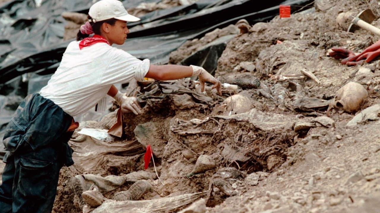 Juli 1996: Eine Mitarbeiterin des UN-Tribunals für Kriegsverbrechen entfernt Erde von Skeletten in einem Massengrab in der Nähe von Srebrenica. Juli 1996: Eine Mitarbeiterin des UN-Tribunals für Kriegsverbrechen entfernt Erde von Skeletten in einem Massengrab in der Nähe von Srebrenica.