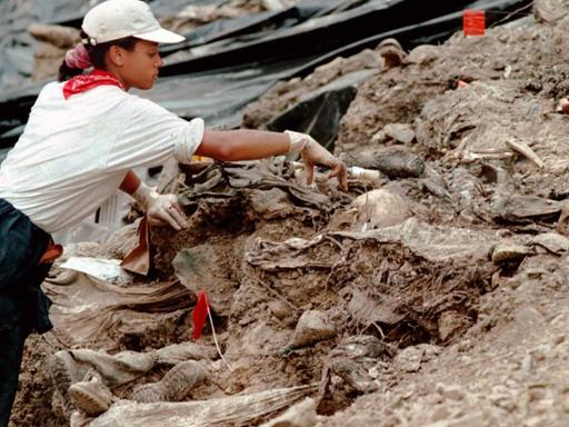 Eine Mitarbeiterin der Sondergruppe des UN-Tribunals für Kriegsverbrechen entfernt am 15.07.1996 Erde von Skeletten in einem Massengrab außerhalb des Dorfes Cerska in der Nähe der früheren Moslem-Enklave Srebrenica, Bosnien-Herzegowina. Die Sondergruppe hatte damals bei ihren Ausgrabungen von Massengräbern erstmals konkrete Beweise für die Ermordung von zahlreichen Vermissten sichergestellt.