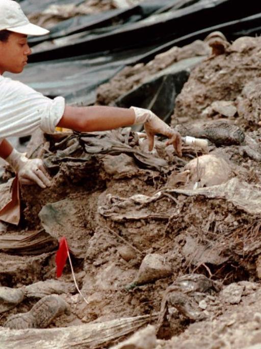 Eine Mitarbeiterin der Sondergruppe des UN-Tribunals für Kriegsverbrechen entfernt am 15.07.1996 Erde von Skeletten in einem Massengrab außerhalb des Dorfes Cerska in der Nähe der früheren Moslem-Enklave Srebrenica, Bosnien-Herzegowina. Die Sondergruppe hatte damals bei ihren Ausgrabungen von Massengräbern erstmals konkrete Beweise für die Ermordung von zahlreichen Vermissten sichergestellt.