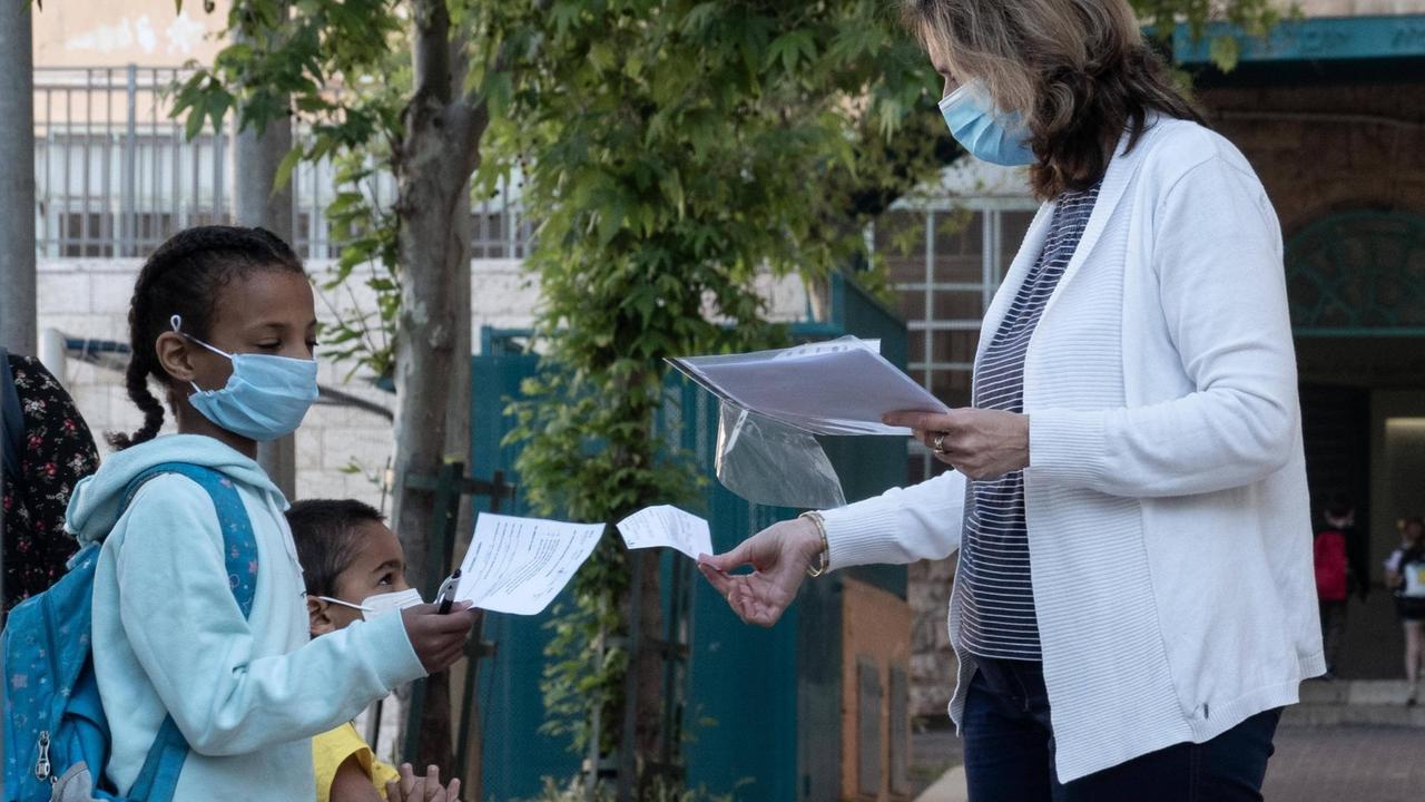 Eine Lehrerin in Jerusalem in Israel mit einer Schülerin - beide tragen Masken - führt Maßnahmen aufgrund des Coronavirus aus, aufgenommen im März 2020. Eine Lehrerin in Jerusalem in Israel mit einer Schülerin - beide tragen Masken - führt Maßnahmen aufgrund des Coronavirus aus, aufgenommen im März 2020.
