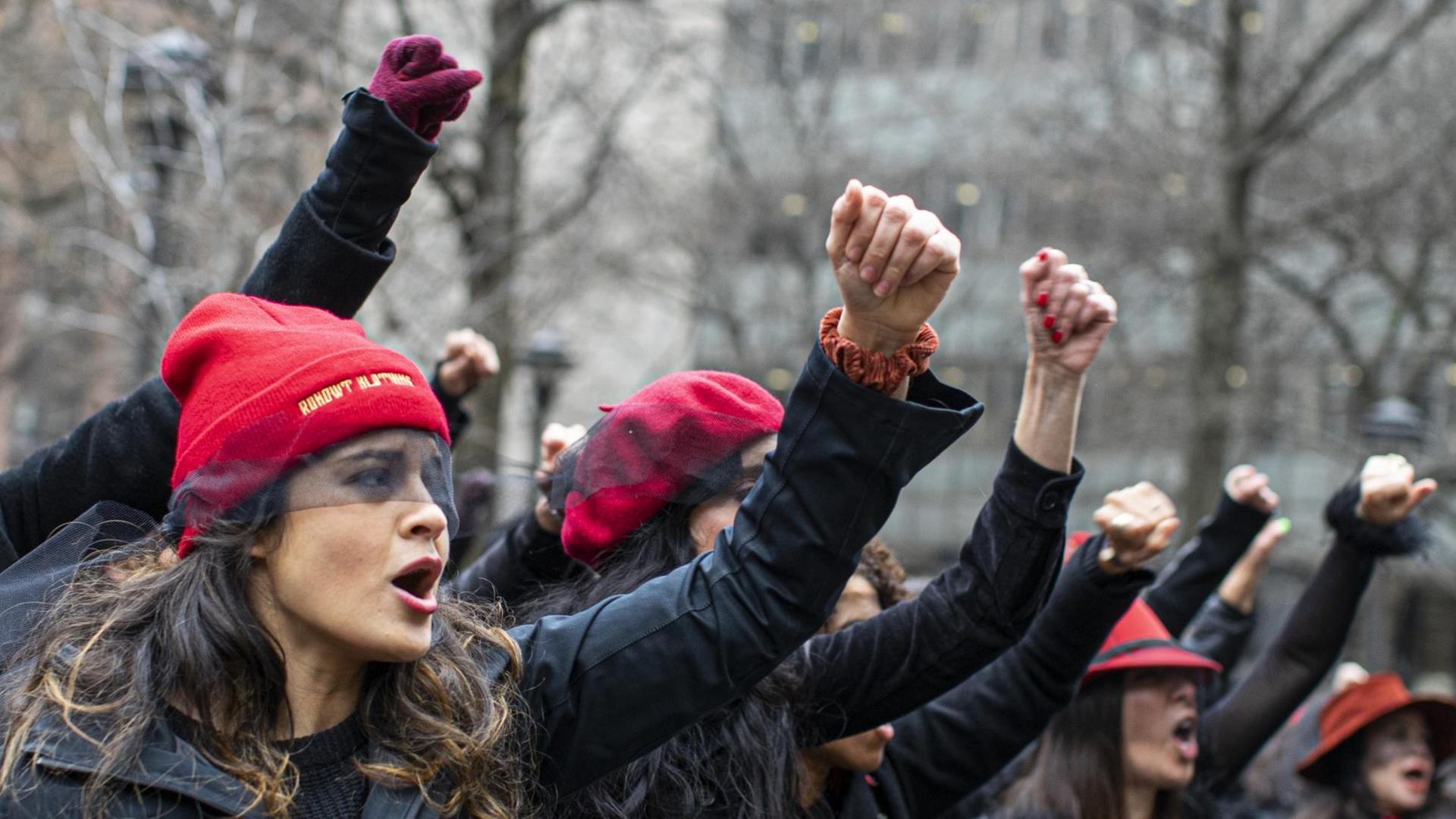 Frauen protestieren und singen, mit erhobenen Fäusten, vor dem Gerichtsgebäude Frauen protestieren und singen, mit erhobenen Fäusten, vor dem Gerichtsgebäude