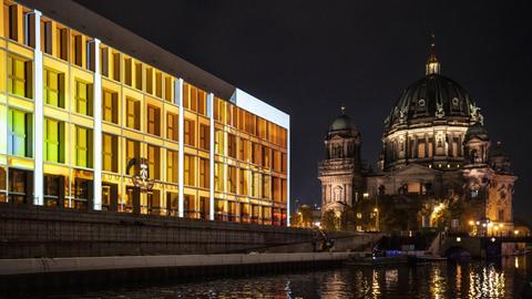 Nachtaufnahme: Zum 30. Jubiläum des Mauerfalls in Berlin werden in den Abendstunden Fotos und Filme an die Fassade des Humboldt Forums projiziert