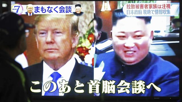 Trump und Kim auf einem TV Monitor, unten und oben asiatische Schriftzeichen im Monitor
