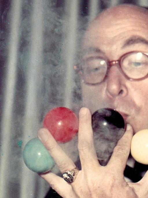Helmut Schreiber bei einem Zaubertrick mit vier Billardkugeln zwischen den Fingern seiner linken Hand