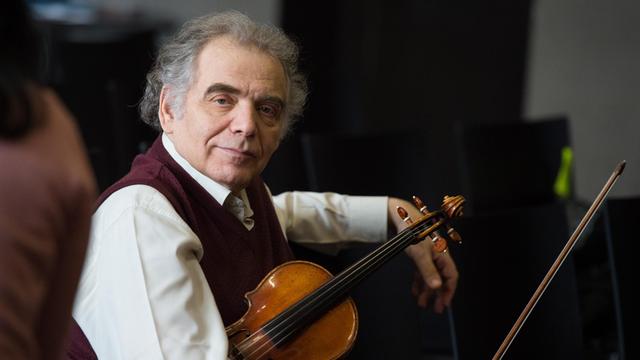 Der Geiger und Violinpädagoge Zakhar Bron im Halbporträt mit Geige unter dem Arm.