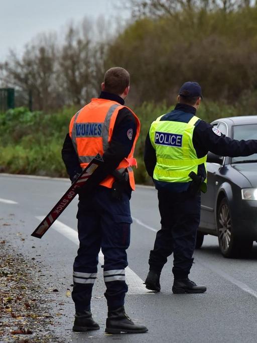 Ein uto wird an der französisch-belgischen Grenze von zwei Beamten gestoppt.
