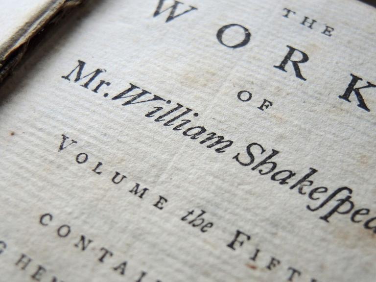 Ein Band einer neunbändigen Gesamtausgabe aus dem Jahr 1760 mit den Werken von William Shakespeare liegt auf einem Tisch.