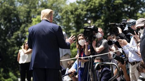 US-Präsident Donald Trump steht mit dem Rücken zum Betrachter vor vielen Journalistinnen und Journalisten