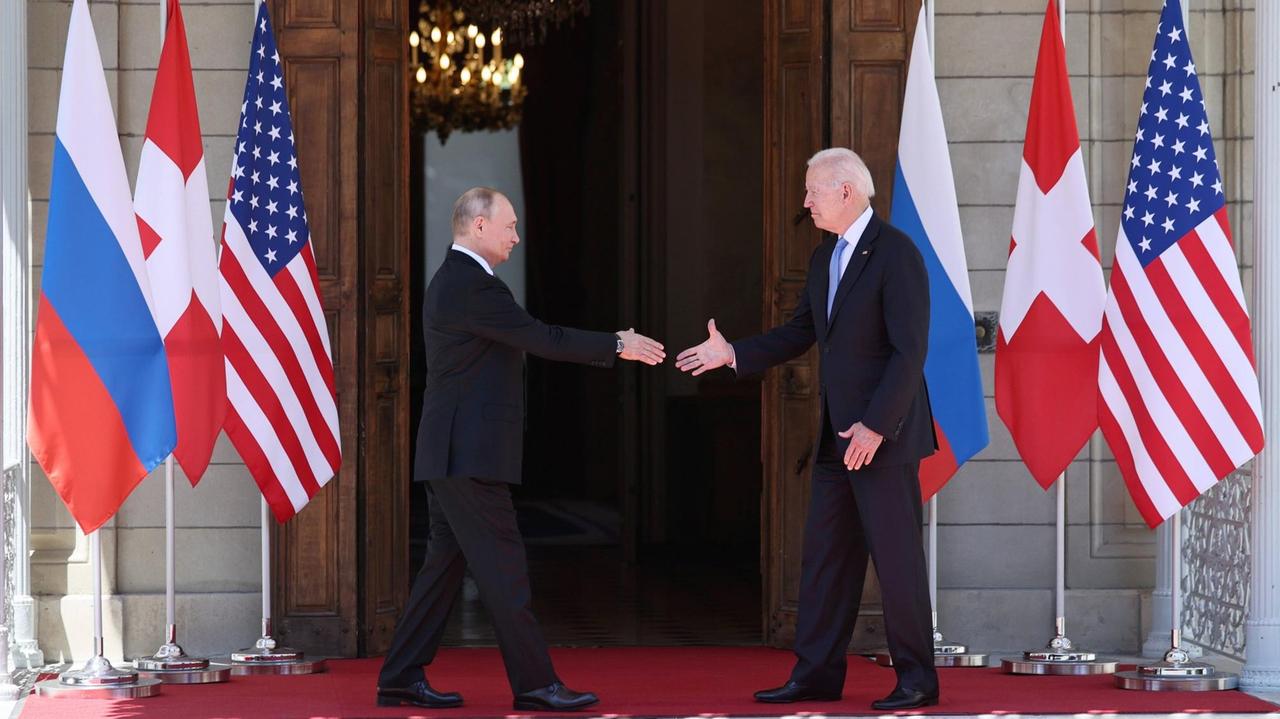 US-Präsident Joe Biden und Russlands Präsident Vladimir Putin stecken beide die Hände zum Handschlag aus.