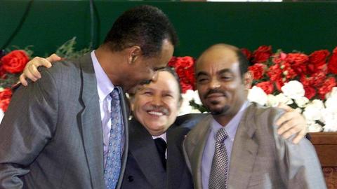 Ein Farbfoto zeigt den algerischen Präsidenten Abdelaziz Bouteflika mit dem Präsidenten Eritreas, Issaias Afewerki links von ihm und Äthiopiens Regierungschef Meles Zenawi rechts im Arm.