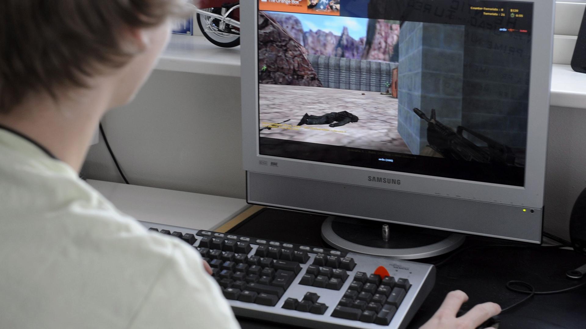 Ein junger Mann spielt einen klassischen Egoshooter. Ein junger Mann spielt einen klassischen Egoshooter.