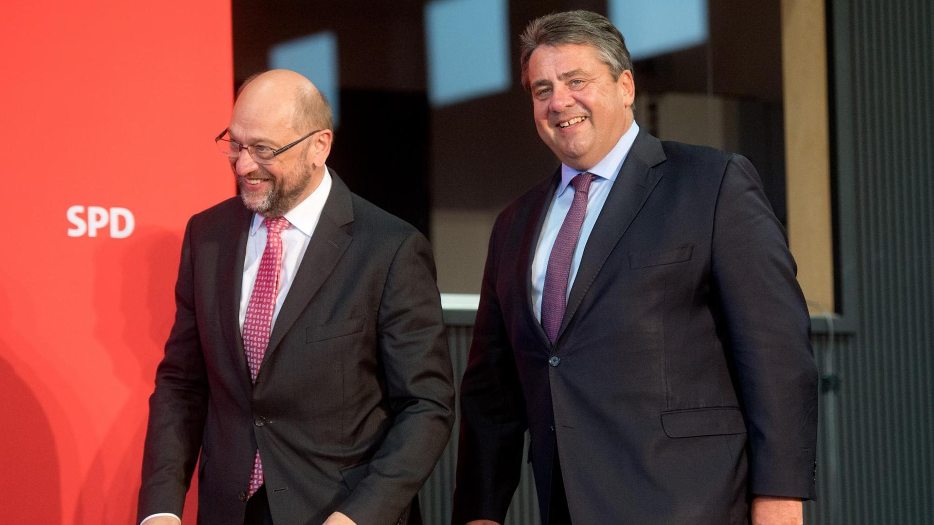 Martin Schulz und Sigmar Gabriel kommen lachend vor einer roten Wand mit SPD-Schriftzug Martin Schulz und Sigmar Gabriel kommen lachend vor einer roten Wand mit SPD-Schriftzug