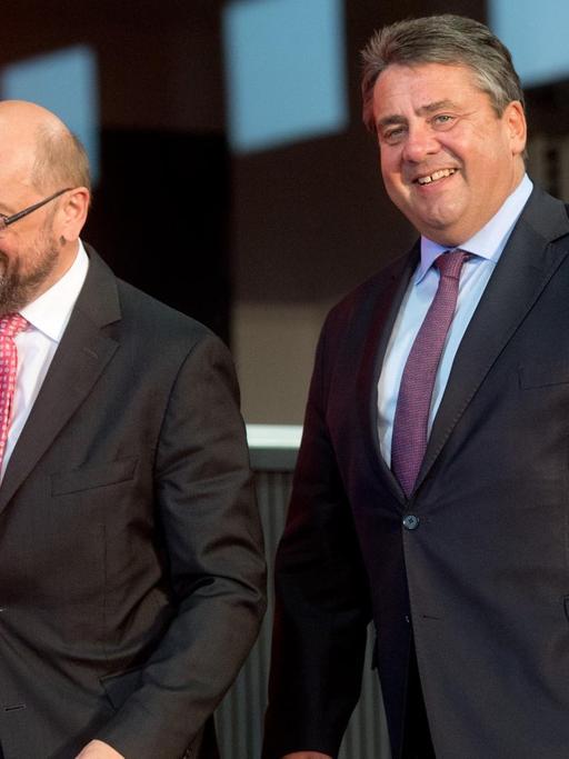 Martin Schulz und Sigmar Gabriel kommen lachend vor einer roten Wand mit SPD-Schriftzug