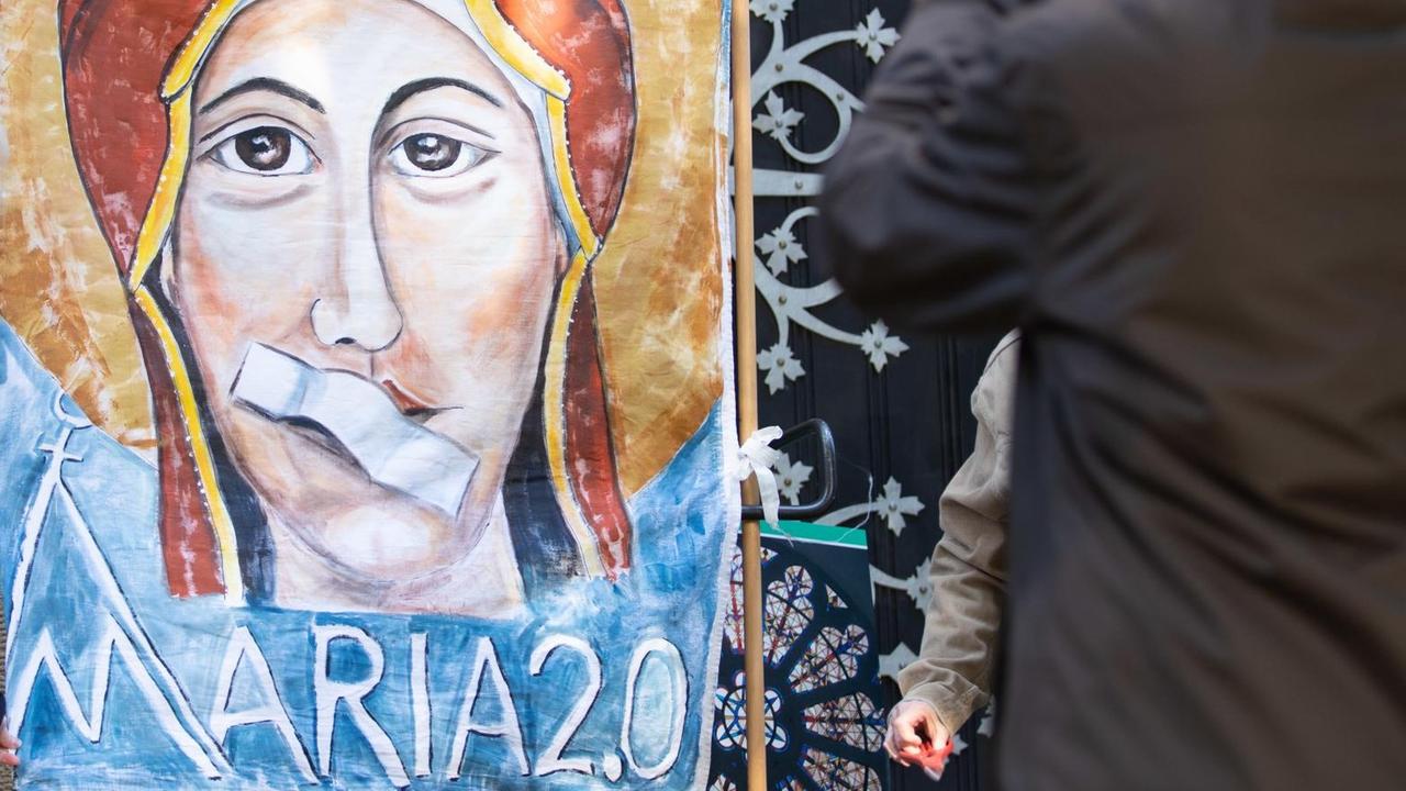 Ein Transparent zeigt Maria, die Mutter Gottes, mit einem Pflaster auf dem Mund anlässlich eines Gottesdienstes unter freiem Himmel. Katholische Frauen und verschiedene Frauen-Initiativen aus mehreren deutschen Bistümern beteiligen sich am Kirchenstreik «Maria 2.0» in Münster am 11.Mai 2019. Ein Transparent zeigt Maria, die Mutter Gottes, mit einem Pflaster auf dem Mund anlässlich eines Gottesdienstes unter freiem Himmel. Katholische Frauen und verschiedene Frauen-Initiativen aus mehreren deutschen Bistümern beteiligen sich am Kirchenstreik «Maria 2.0» in Münster am 11.Mai 2019.