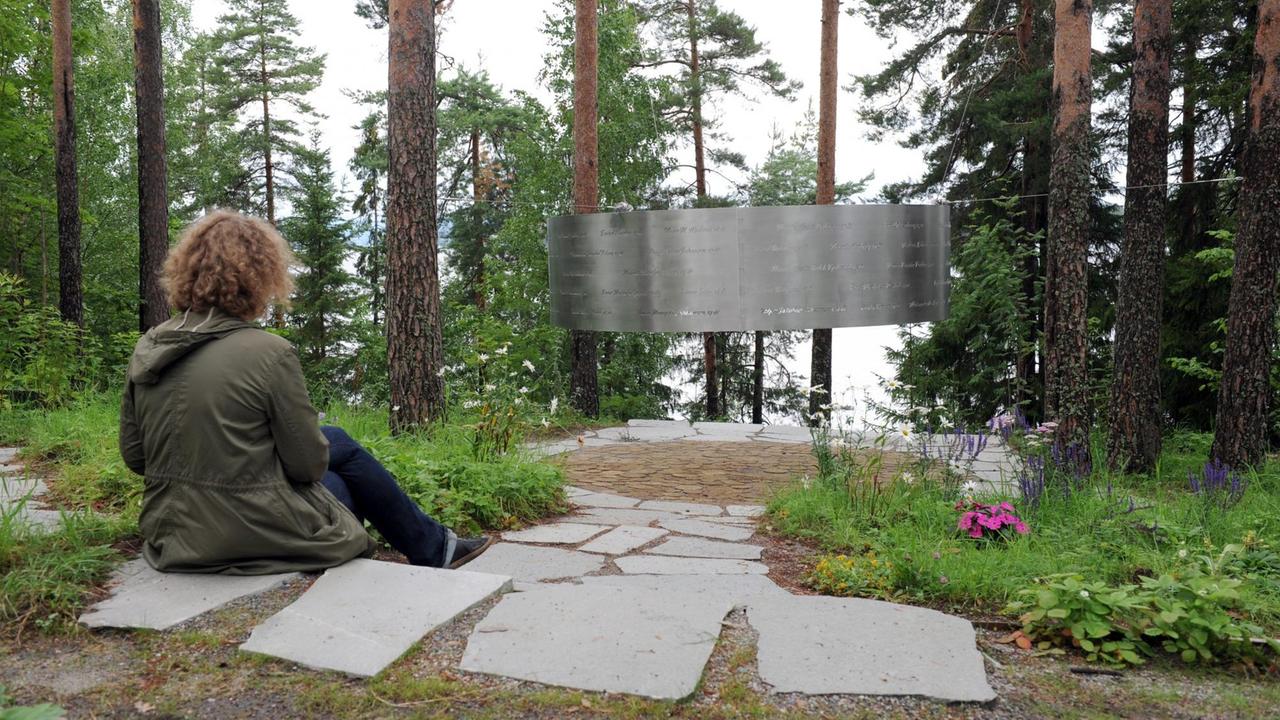 Eine Frau sitzt am 05.08.2015 auf der Insel Utøya (Norwegen) vor einem stählernen Ring, in den die Namen der Opfer der Terroranschläge eingraviert sind . Vier Jahre nach den Terroranschlägen von Anders Behring Breivik lädt die Jugendorganisation der norwegischen Arbeiterpartei (AUF) wieder zu einem Sommerlager auf der Insel Utøya ein. Eine Frau sitzt am 05.08.2015 auf der Insel Utøya (Norwegen) vor einem stählernen Ring, in den die Namen der Opfer der Terroranschläge eingraviert sind . Vier Jahre nach den Terroranschlägen von Anders Behring Breivik lädt die Jugendorganisation der norwegischen Arbeiterpartei (AUF) wieder zu einem Sommerlager auf der Insel Utøya ein.