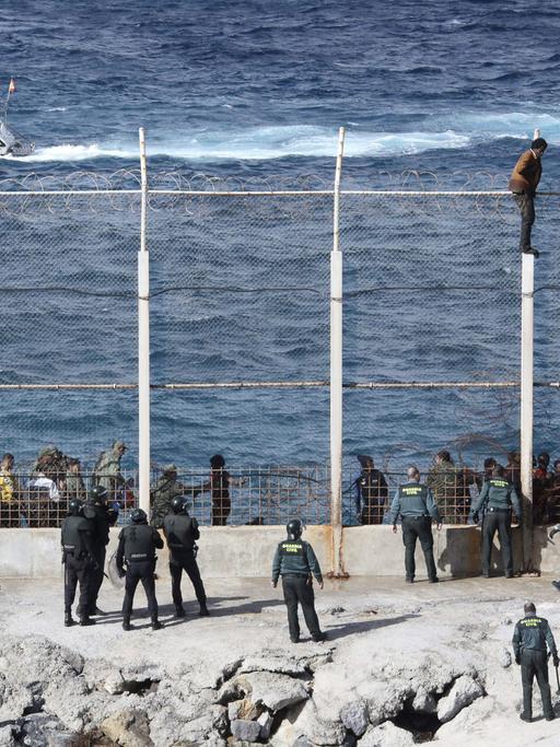 Menschen versuchen am 3.2.2015, den Grenzzaun der spanischen Exklave Ceuta in Nordafrika zu überwinden.