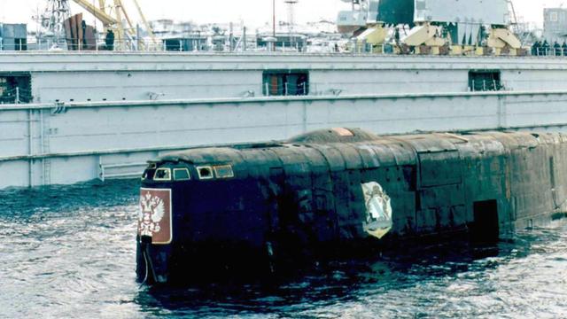Das stark beschädigte, havarierte Atom-U-Boot Kursk neben dem Hochseeschlepper Singapur am 23. Oktober 2001 im Hafen von Rosljakowo,