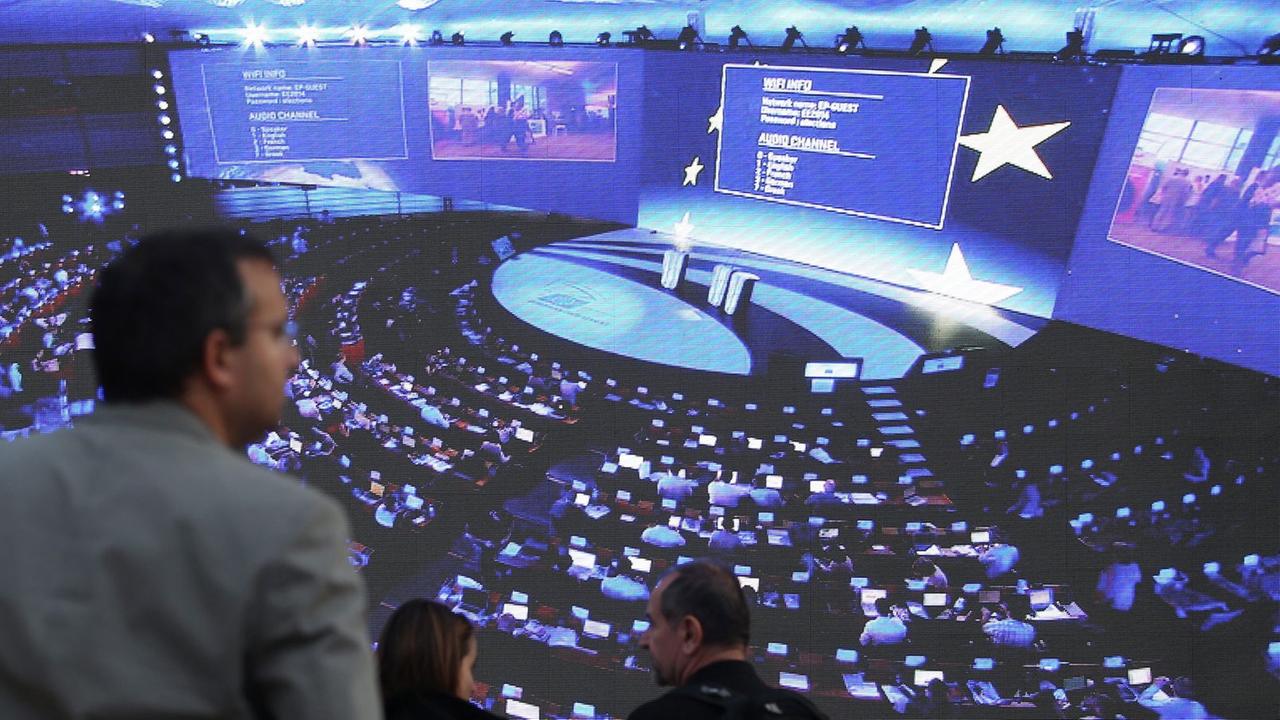Zuschauer warten in Brüssel vor einer Videoleinwand, die Bilder aus dem Europäischen Parlament überträgt, auf die Ergebnisse der Europa-Wahl 2014. Zuschauer warten in Brüssel vor einer Videoleinwand, die Bilder aus dem Europäischen Parlament überträgt, auf die Ergebnisse der Europa-Wahl 2014.