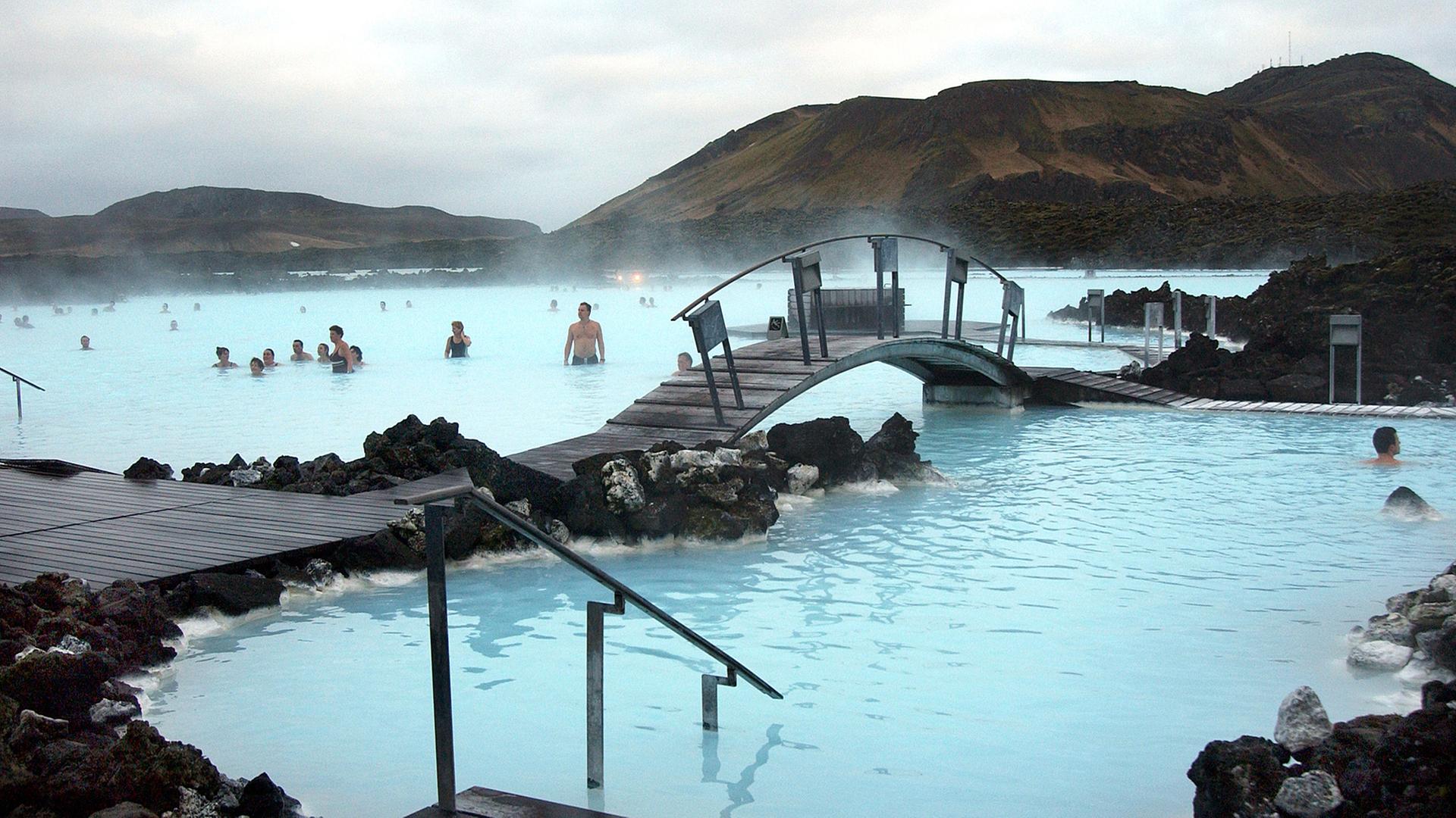 Badende vergnügen sich in dem türkisfarbenen Wasser der Blauen Lagune bei Reykjavík, Island. Badende vergnügen sich in dem türkisfarbenen Wasser der Blauen Lagune bei Reykjavík, Island.