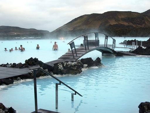 Badende vergnügen sich in dem türkisfarbenen Wasser der Blauen Lagune bei Reykjavík, Island.