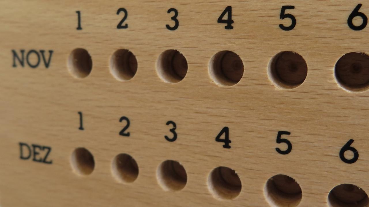 blick auf einen hölzernen Jahreskalender mit den Monaten Oktober, November und Dezember blick auf einen hölzernen Jahreskalender mit den Monaten Oktober, November und Dezember