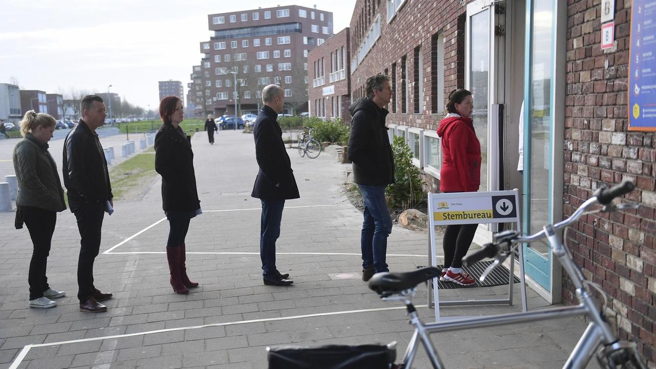 Wähler stehen vor einem Wahllokal in Den Haag Schlange. Wähler stehen vor einem Wahllokal in Den Haag Schlange.
