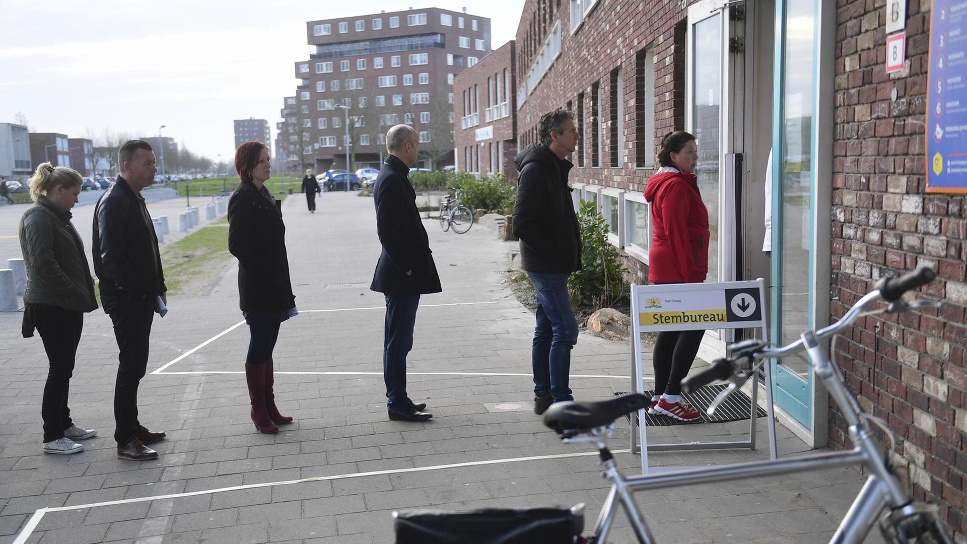 Wähler stehen vor einem Wahllokal in Den Haag Schlange.